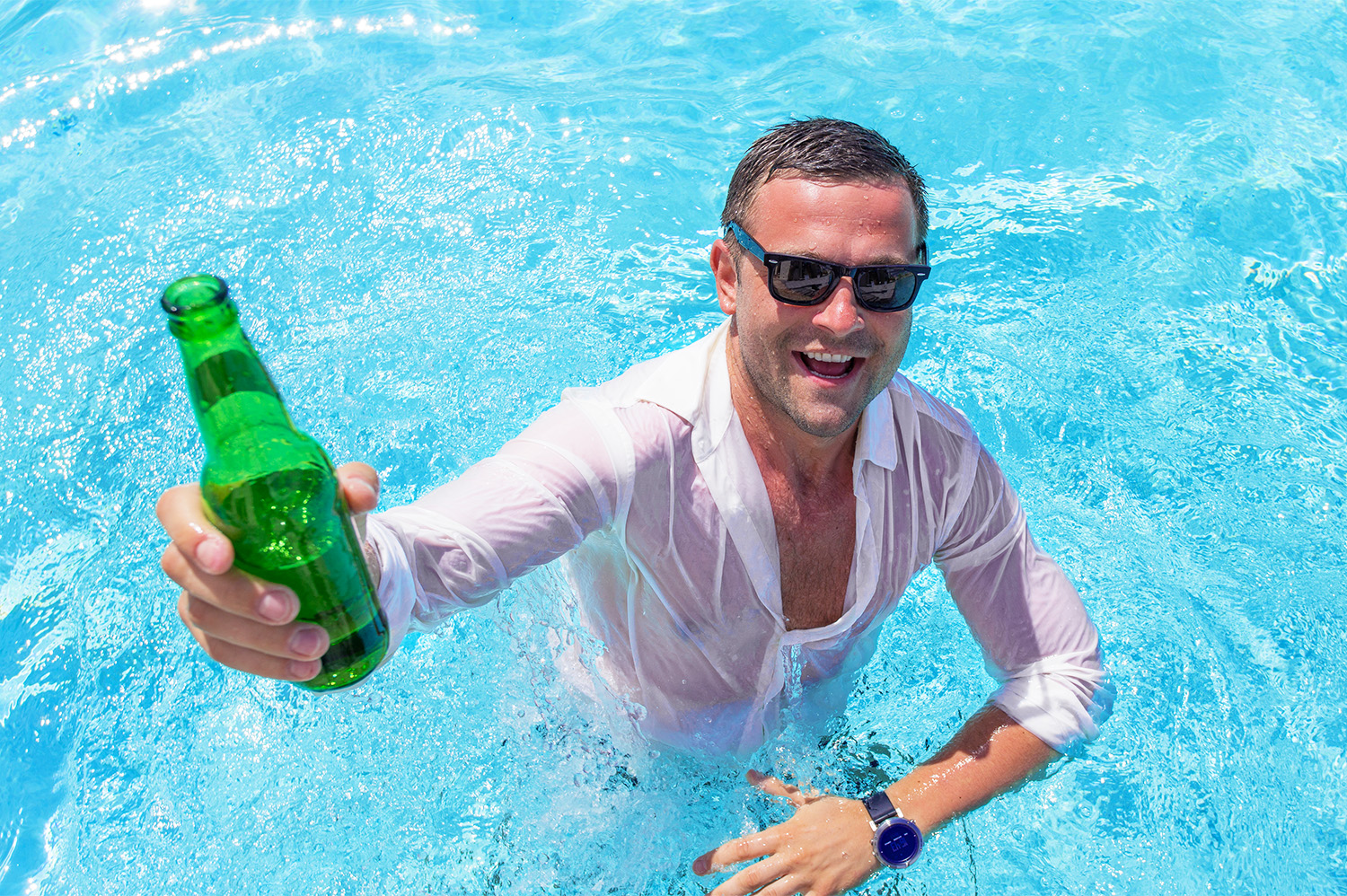 Man in a pol holding a green beer bottle, enjoying his bachelor party.
