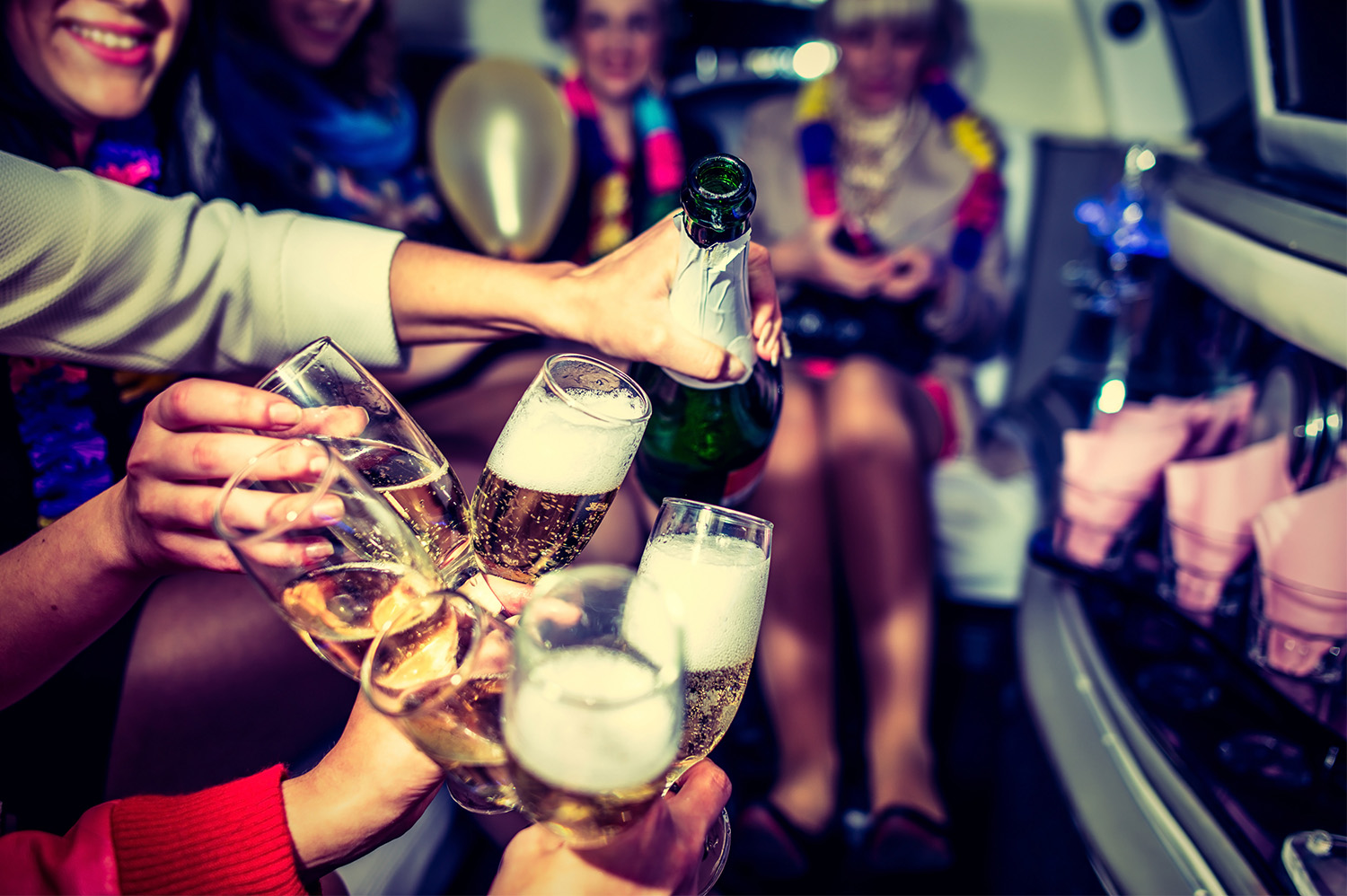 People cheers-ing flutes of champagne after renting a party bus in Scottsdale.